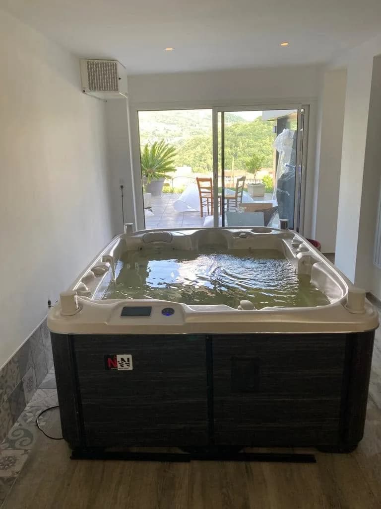 Installation d'un spa Rødberg Full option à Bellegarde, à l'intérieur, devant une baie vitrée