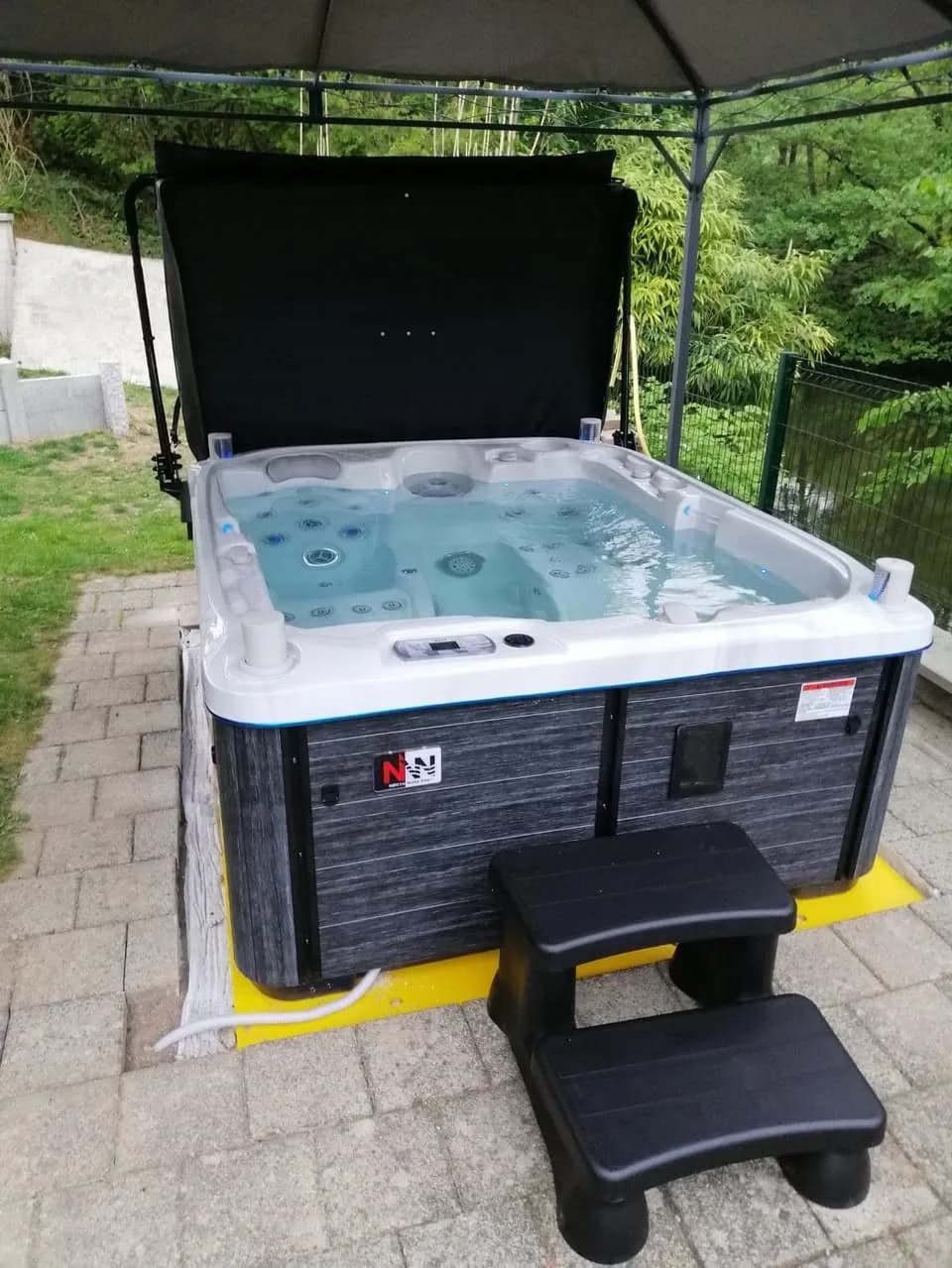 Installation d'un spa Rødberg Full option dans le Haut-Rhin, sur une dalle pavée, avec marchepied