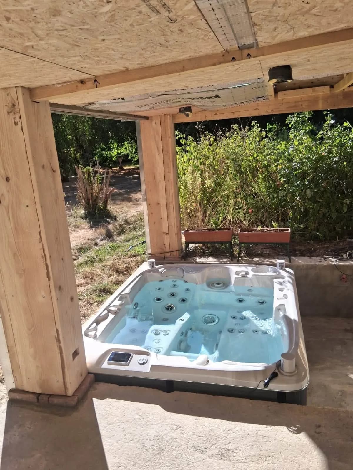 Installation d'un spa Rødberg Full option à La Gonfrière, sous un préau à charpente en bois