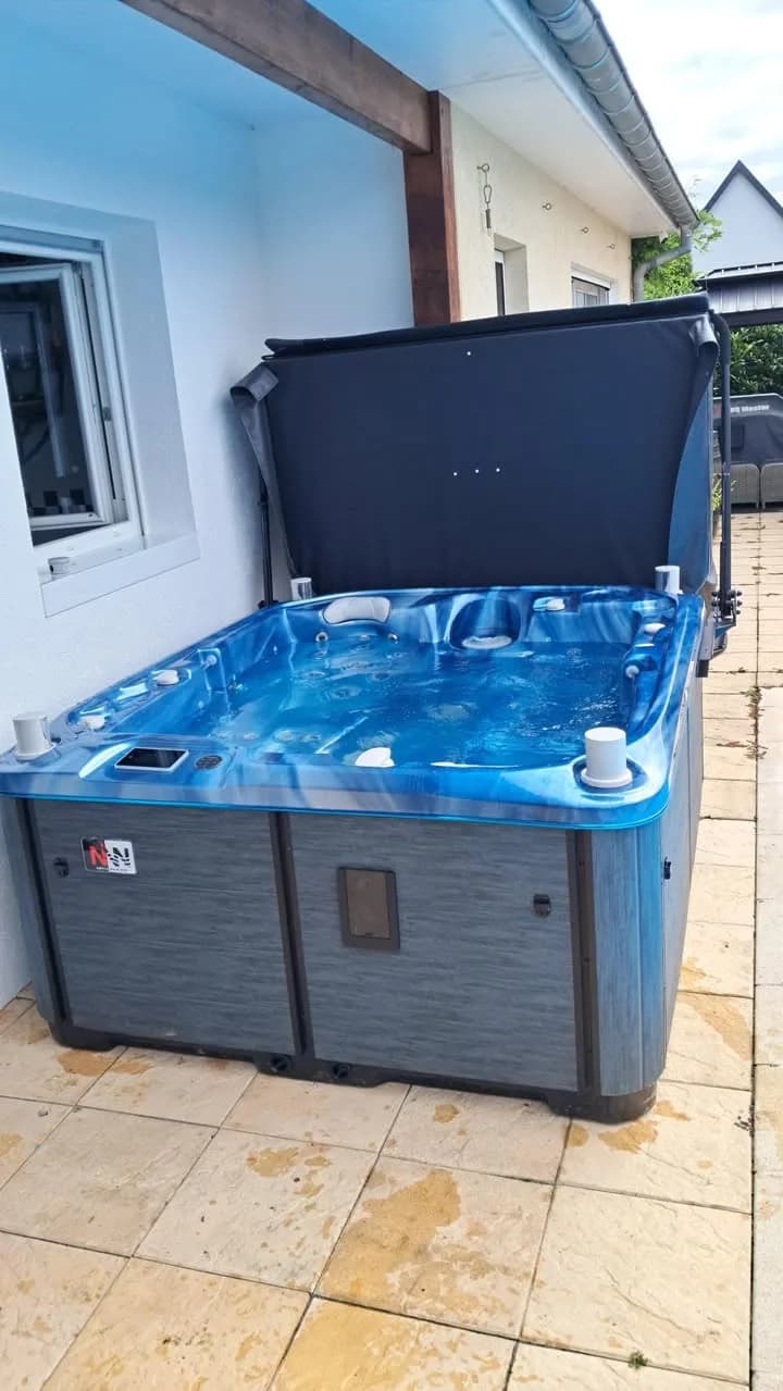 Installation d'un spa Rødberg Full option à Linsdorf, au bord d'une piscine, cuve bleue marbrée