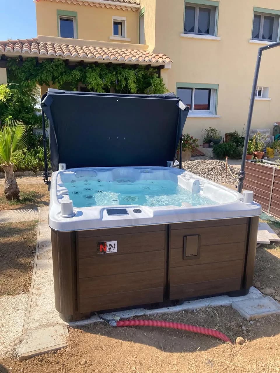 Installation d'un spa Rødberg Full option à Saint-Mitre-les-Remparts, devant la maison, tablier brun