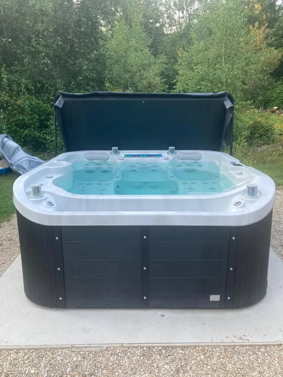 Installation d'un spa Røgaland à Chevreuse, sur une dalle devant les arbres