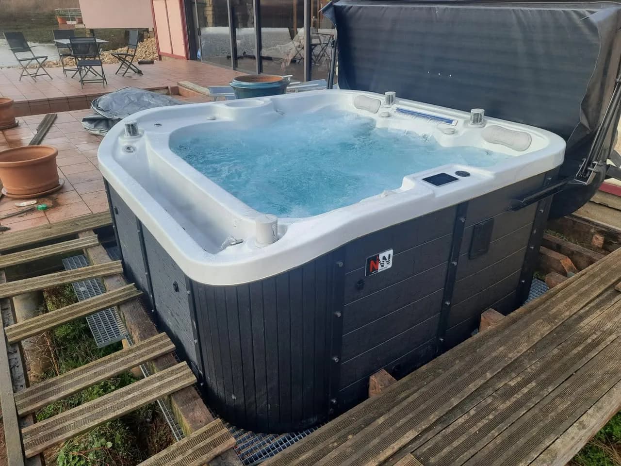 Installation d'un spa Røgaland à Hamonville, sur une terrasse en bois au bord d'un étang