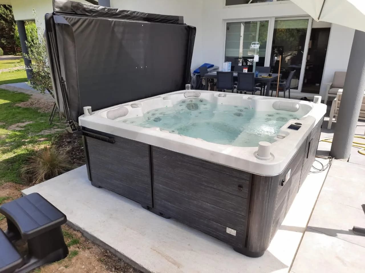 Installation d'un spa Sølveijg à Balbronn, sur une terrasse carrelée, lève-couverture