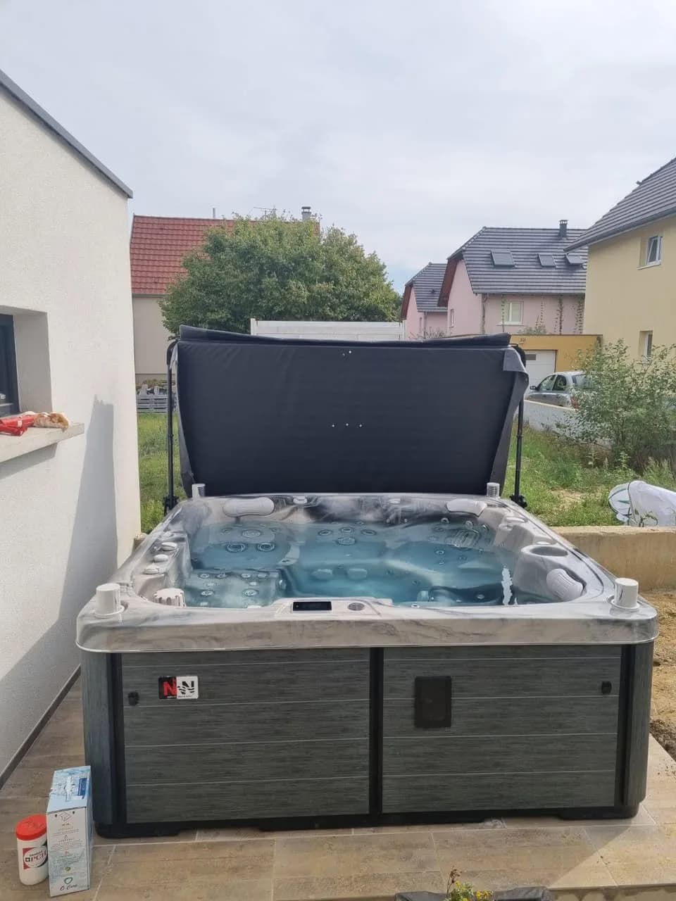 Installation d'un spa Sølveijg à Bartenheim, contre une maison blanche, cuve Odyssey