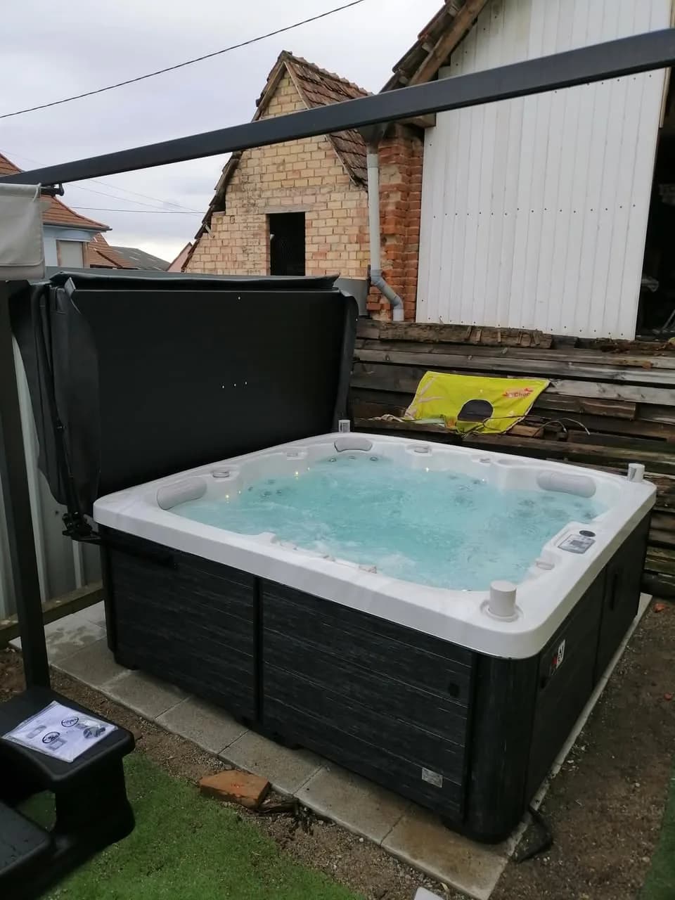 Installation d'un spa Sølveijg dans le Doubs, sur une terrasse, lève-couverture