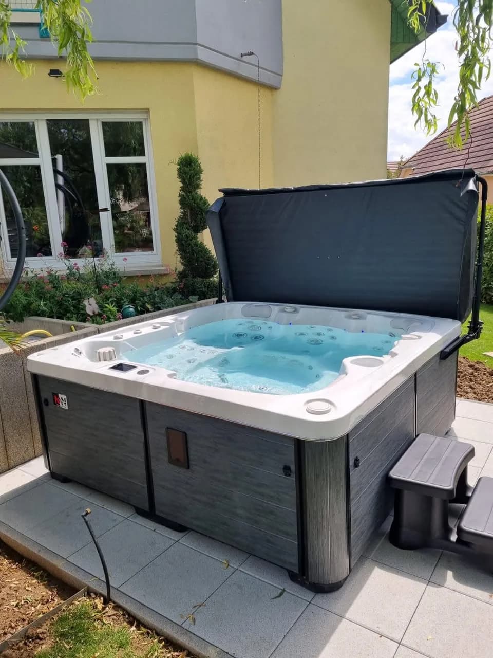 Installation d'un spa Sølveijg à Eguisheim, sur une dalle de jardin, marchepied et lève-couverture