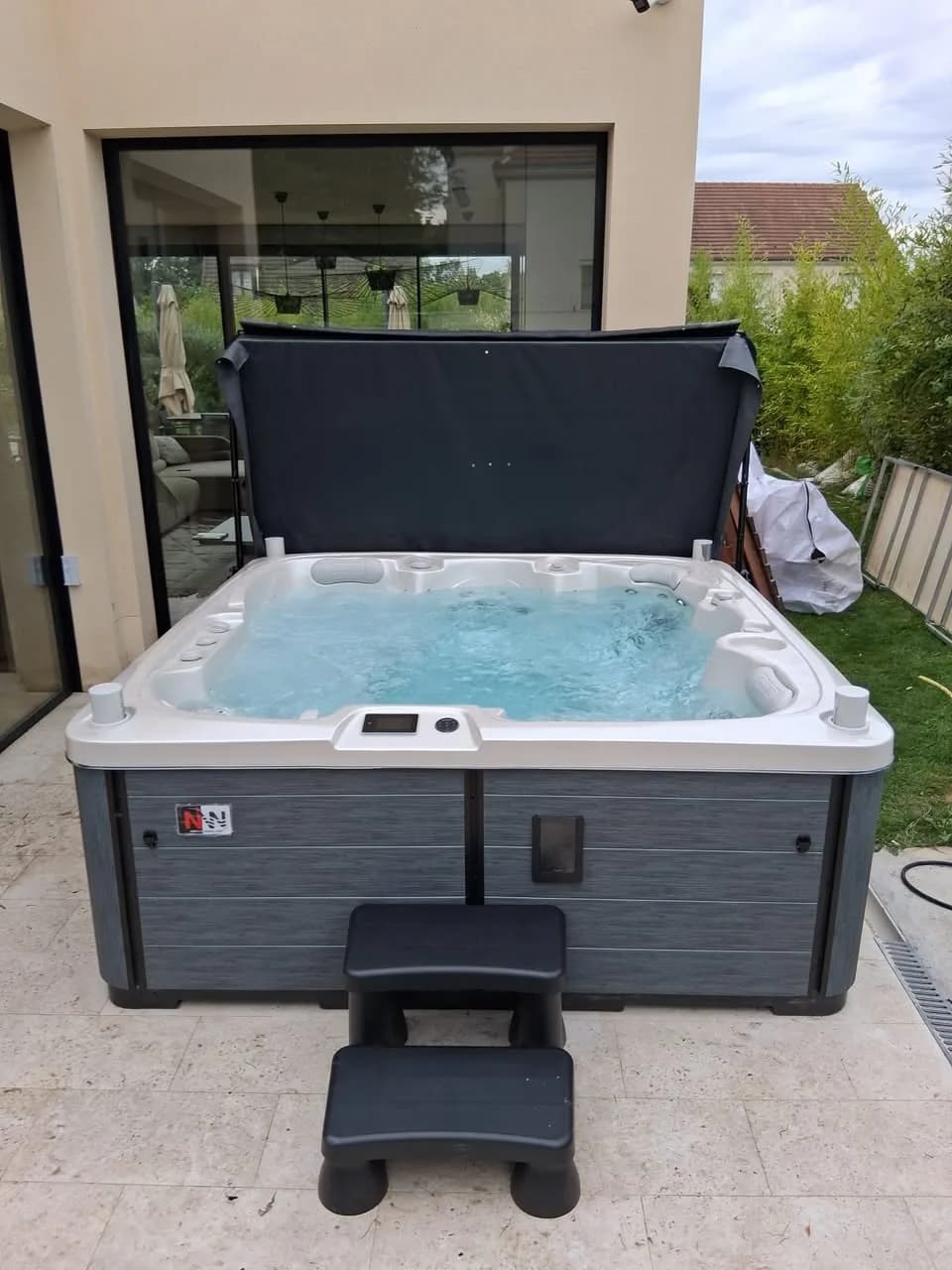 Installation d'un spa Sølveijg Full option à Bussy-Saint-Georges, sur une terrasse dallée devant la maison