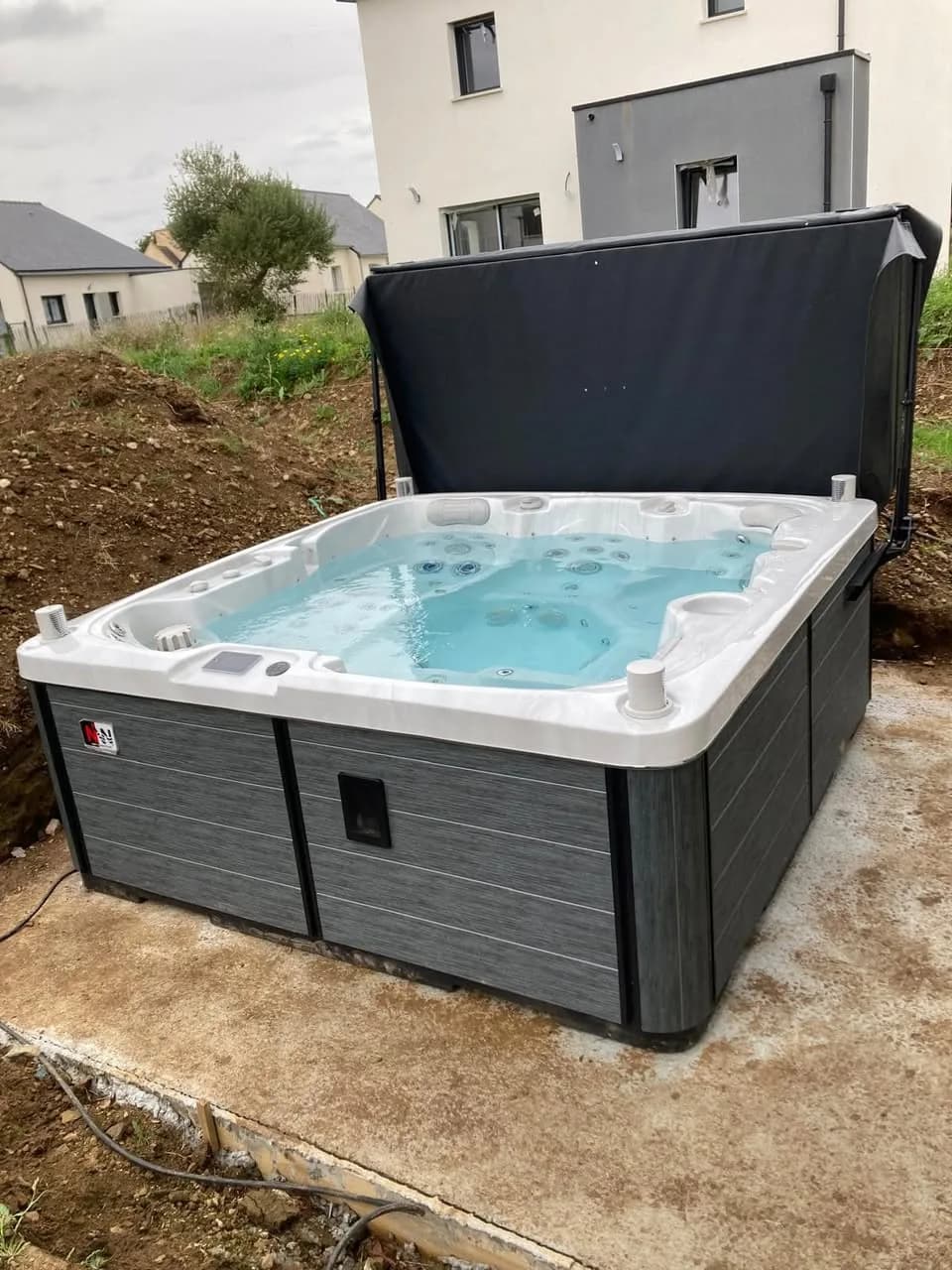 Installation d'un spa Sølveijg Full option à Douarnenez, sur une dalle, couverture relevée
