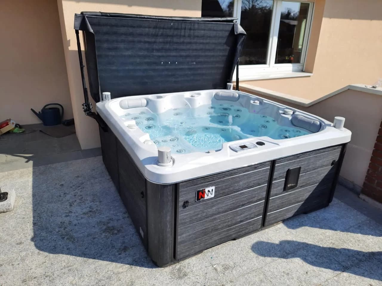 Installation d'un spa Sølveijg Full option à Kembs, sur une terrasse contre la maison, lève-couverture