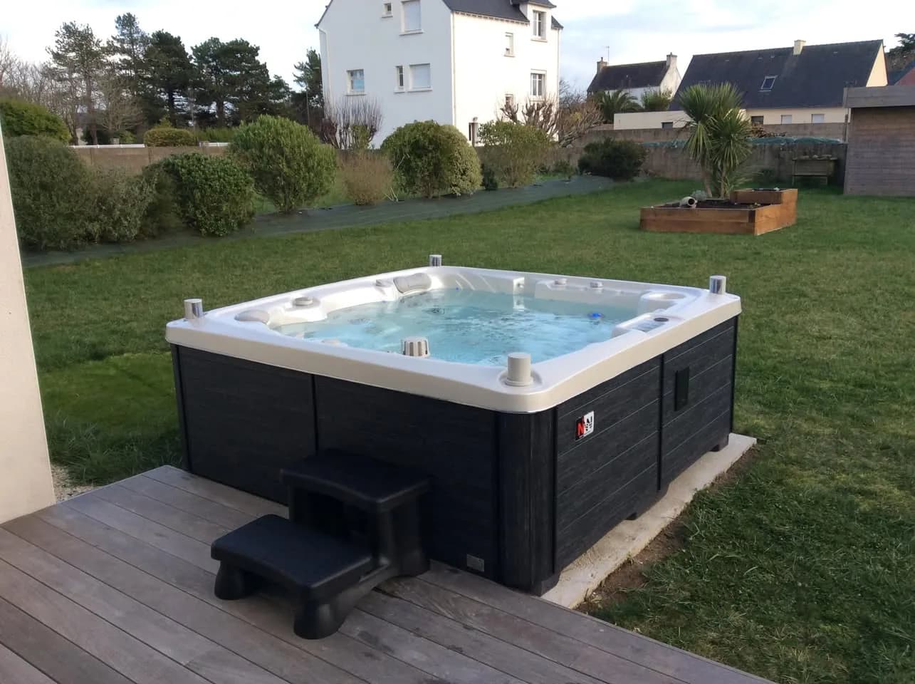 Installation d'un spa Sølveijg Full option à Loctudy, contre une terrasse en bois, marchepied