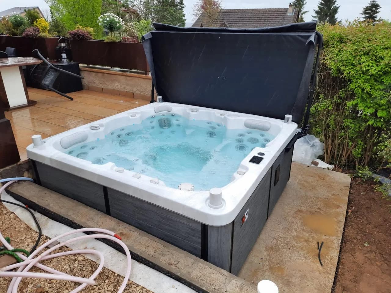 Installation d'un spa Sølveijg Full option à Ludres, sur une terrasse carrelée, lève-couverture