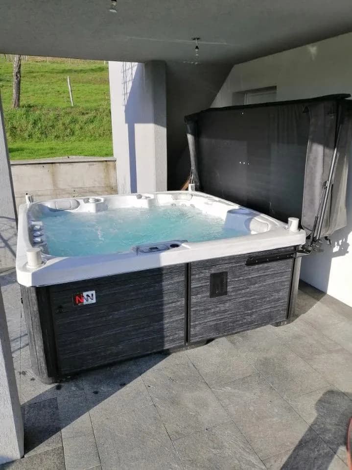Installation d'un spa Sølveijg Full option à Muespach, sous une terrasse couverte, lève-couverture