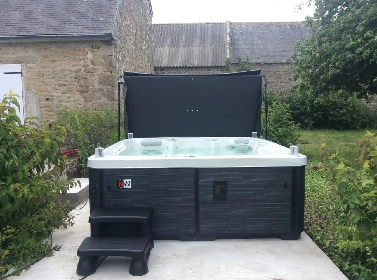 Installation d'un spa Sølveijg Full option à Ploemeur, sur une dalle béton dans un jardin
