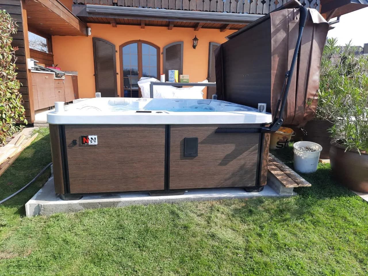 Installation d'un spa Sølveijg Full option à Pulversheim, sur une dalle au bord du gazon, tablier brun