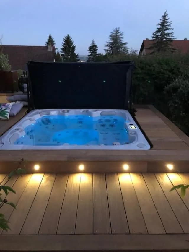 Installation d'un spa Sølveijg Full option à Richwiller, encastré dans une terrasse en bois éclairée par des spots