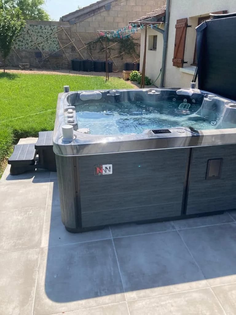 Installation d'un spa Sølveijg Full option à Sancé, sur une terrasse carrelée en bordure de pelouse