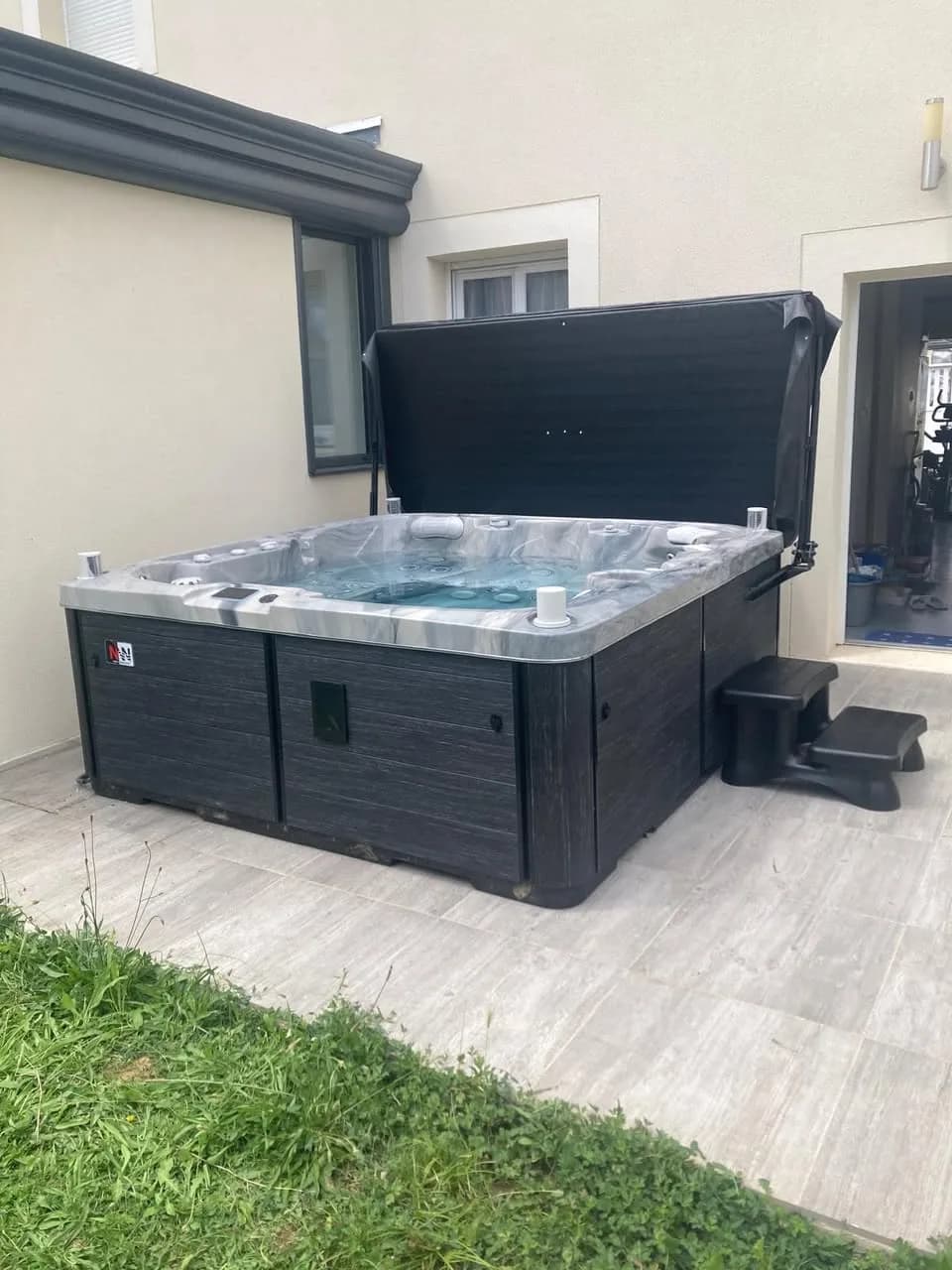 Installation d'un spa Sølveijg Full option à Savigny-sur-Orge, sur une terrasse carrelée au pied de la maison