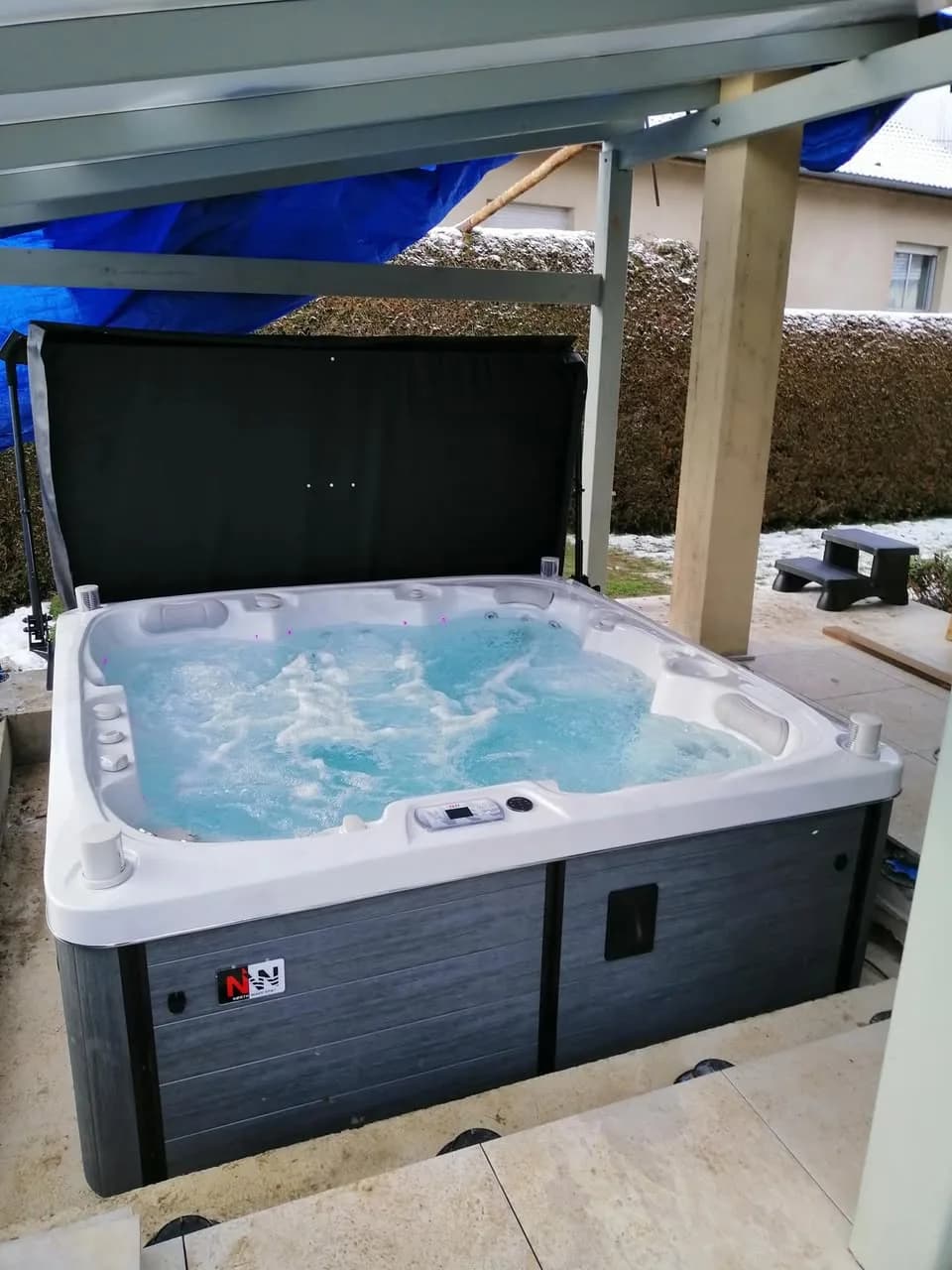 Installation d'un spa Sølveijg Full option à Tavey, sous un auvent, lève-couverture