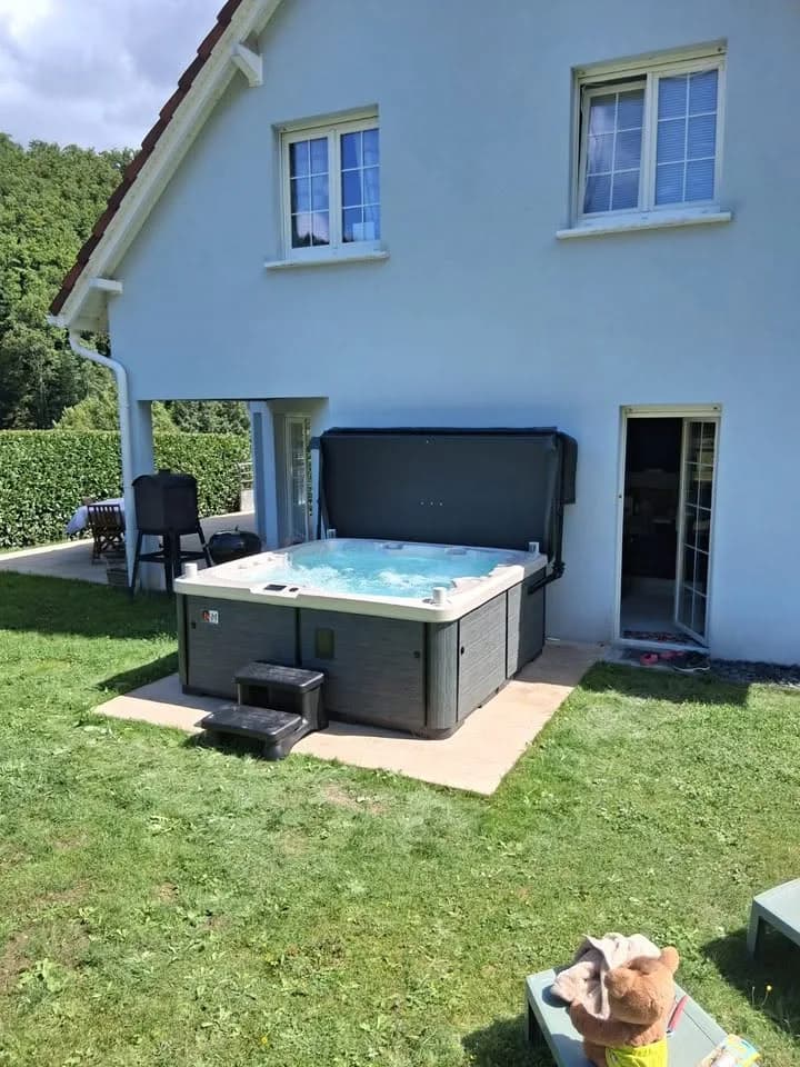 Installation d'un spa Sølveijg Full option à Urbeis, sur une dalle dans le jardin, couverture relevée