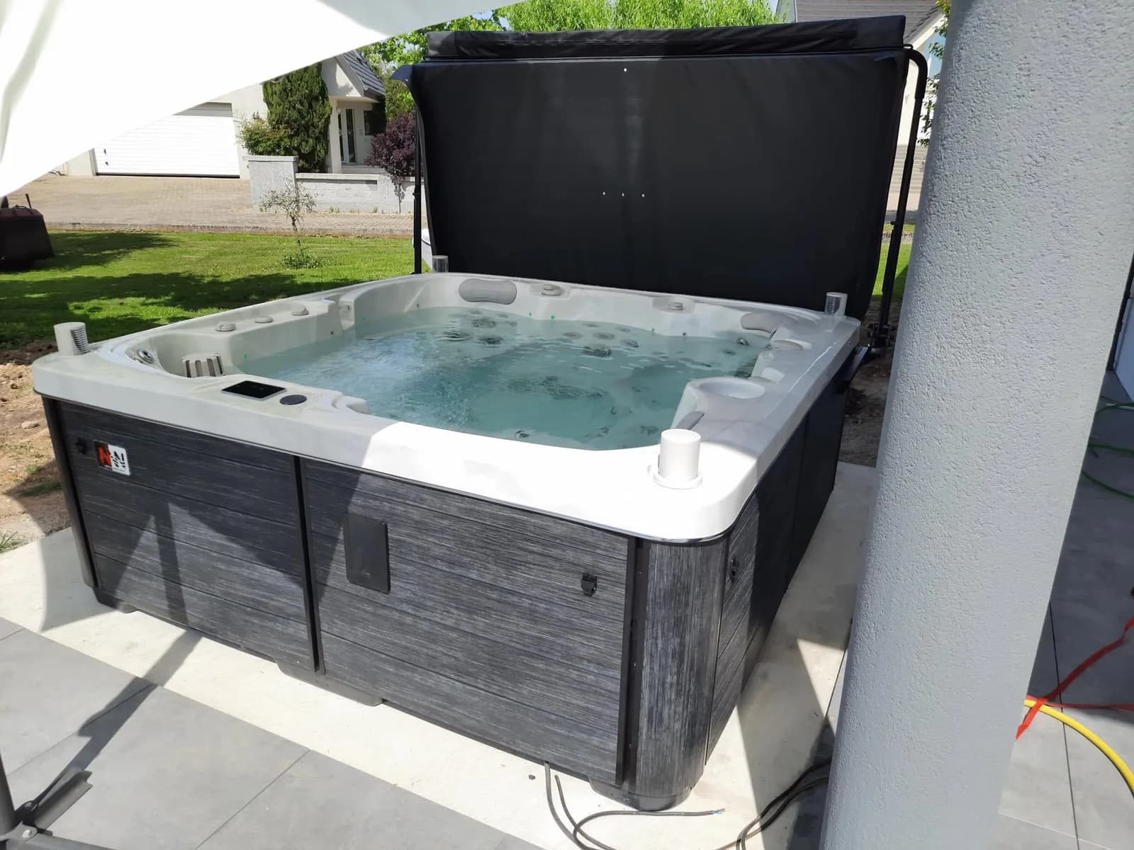 Installation d'un spa Sølveijg Full option à Weyersheim, sur une dalle carrelée, lève-couverture