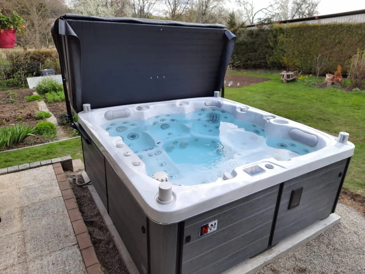 Installation d'un spa Sølveijg Full option à Willer, dans un jardin, lève-couverture