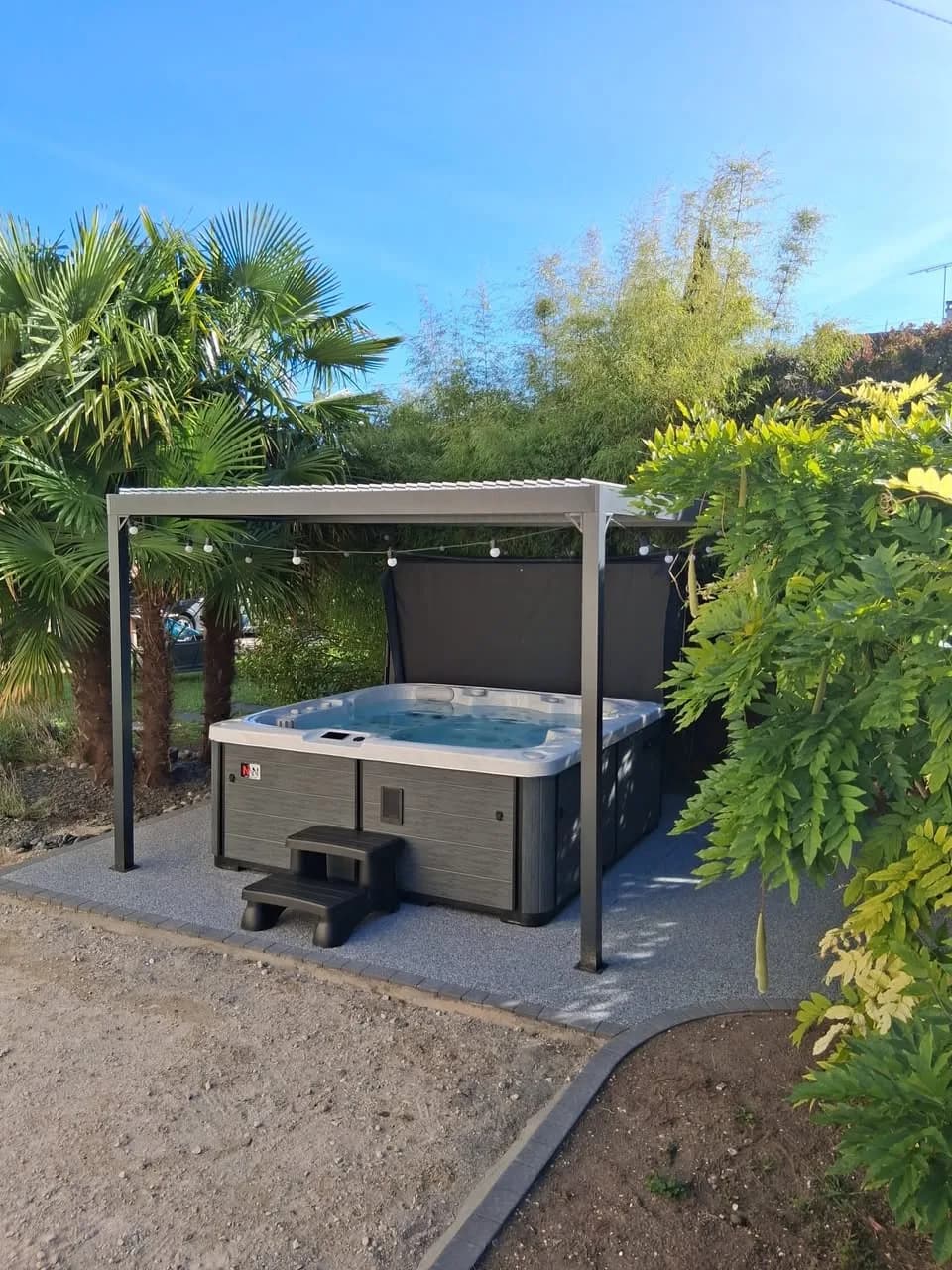 Installation d'un spa Sølveijg Full option, sous une pergola au fond du jardin
