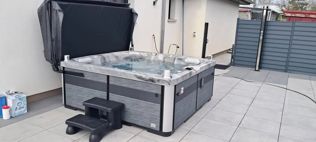 Installation d'un spa Sølveijg à Hagenbach, sur une terrasse carrelée, lève-couverture