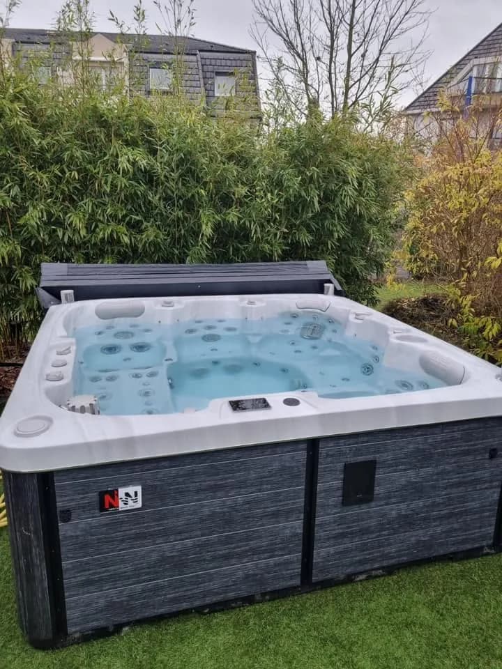 Installation d'un spa Sølveijg à Lipsheim, sur une pelouse devant des bambous
