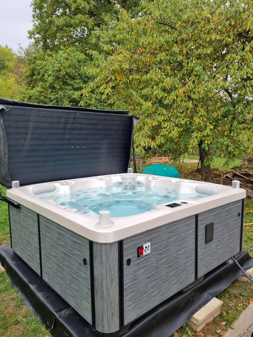 Installation d'un spa Sølveijg à Lutzelhouse, dans un verger, lève-couverture