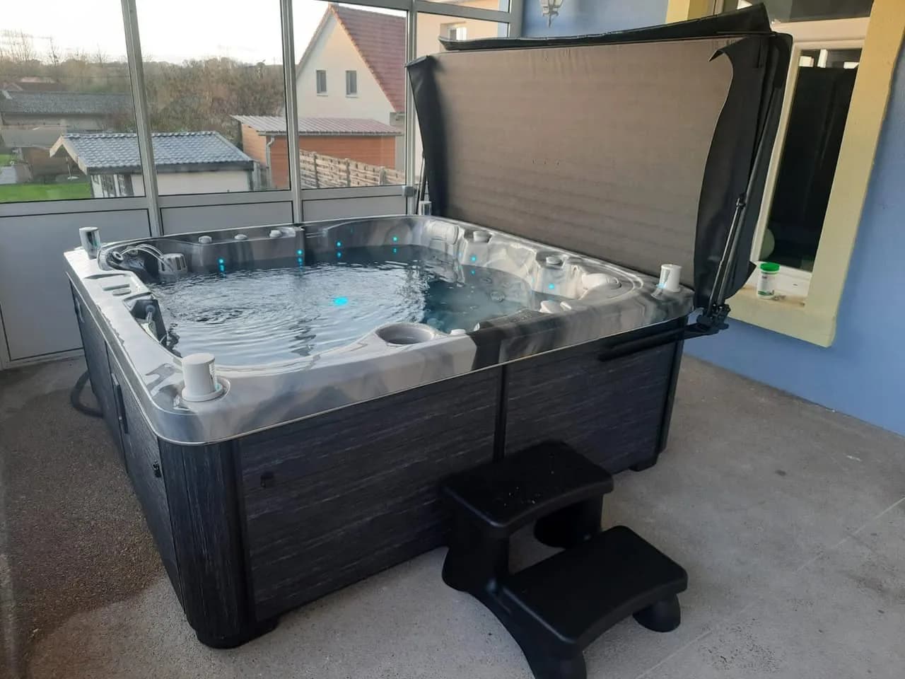 Installation d'un spa Sølveijg à Mézire, dans une véranda, marchepied
