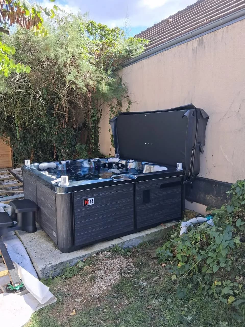 Installation d'un spa Sølveijg à Palaiseau, dans un coin de jardin contre un mur