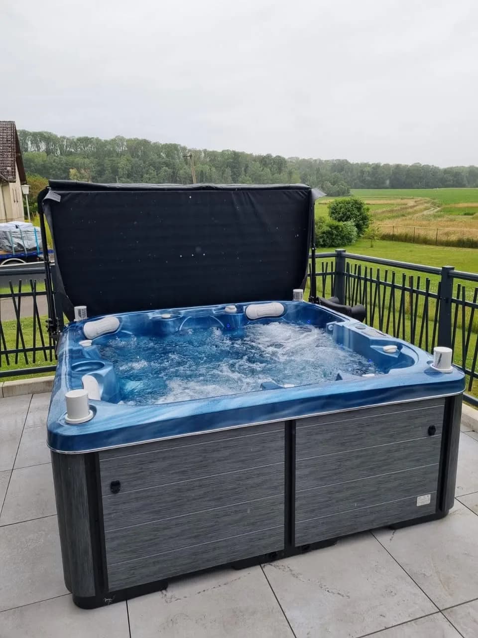 Installation d'un spa Sørrana à Aspach-le-Bas, sur une terrasse carrelée, vue sur les champs