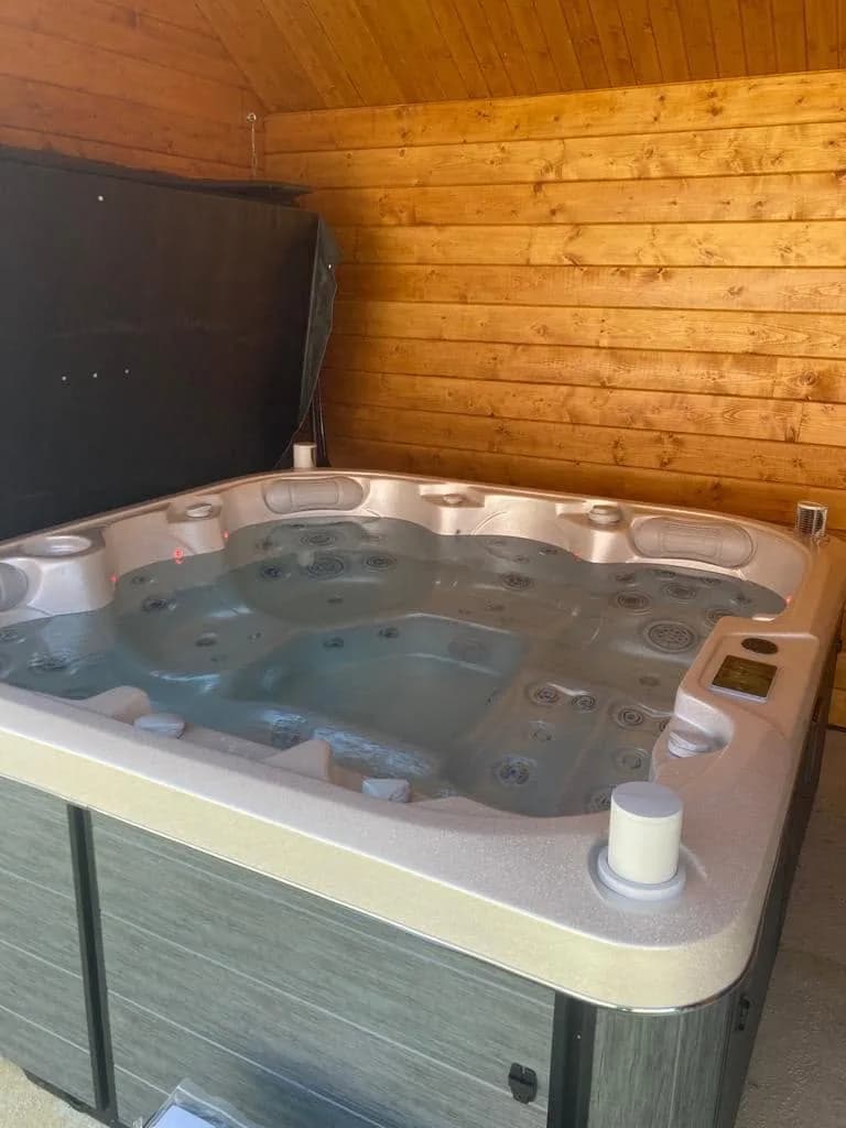 Installation d'un spa Sørrana à Authoison, sous un abri en lambris de bois