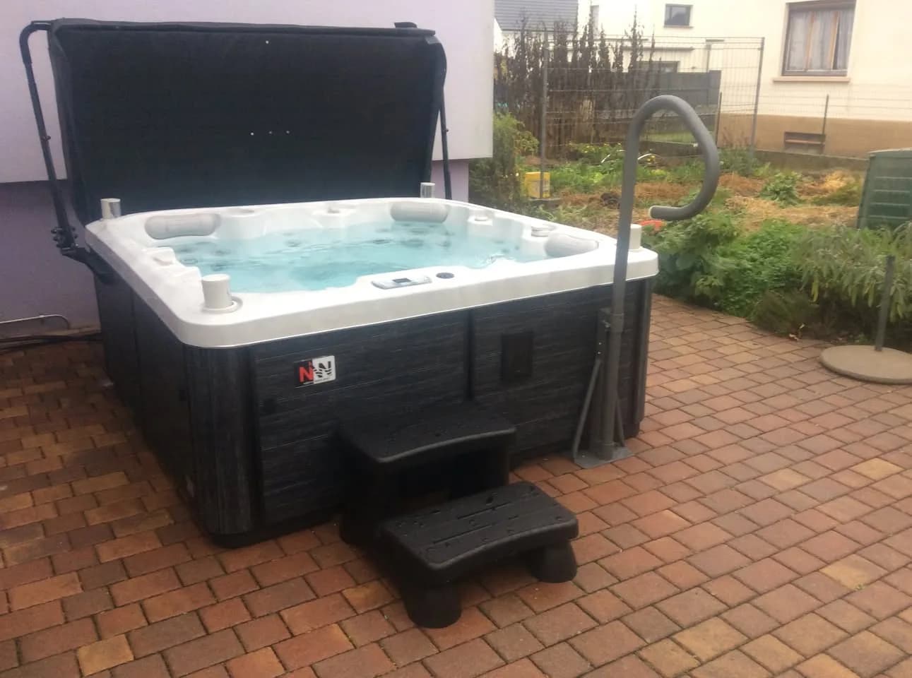 Installation d'un spa Sørrana Full option à Kembs, sur une terrasse pavée, barre d'appui