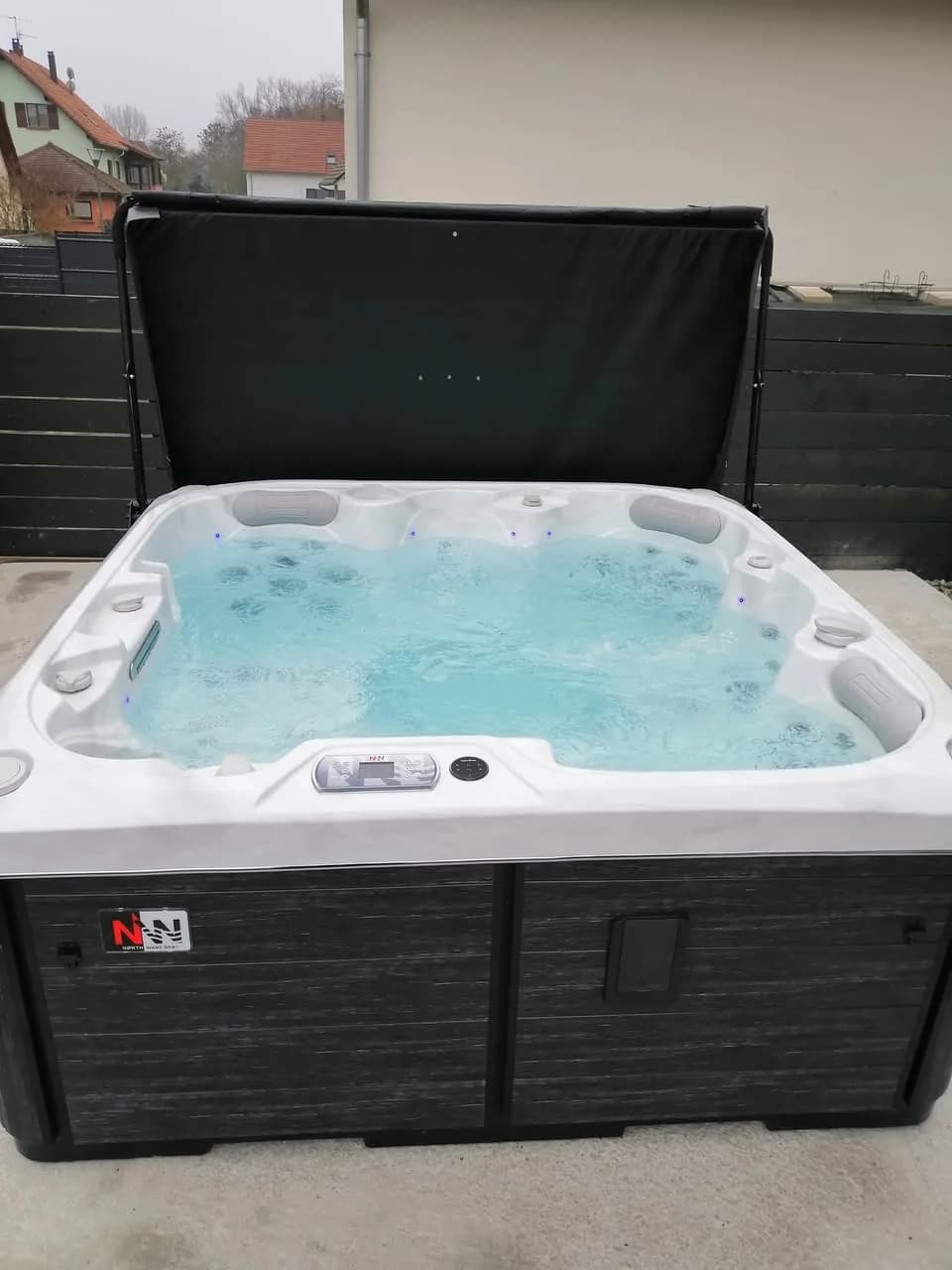 Installation d'un spa Sørrana Full option à Seltz, contre la maison, lève-couverture