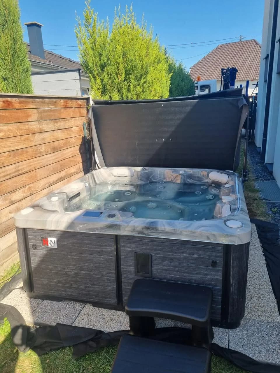 Installation d'un spa Sørrana à Niederhausbergen, contre un bardage en bois, cuve Odyssey