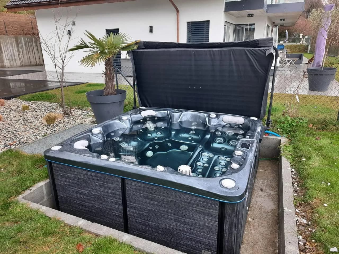 Installation d'un spa Søvik à Blonay, dans un encadrement en béton, cuve foncée