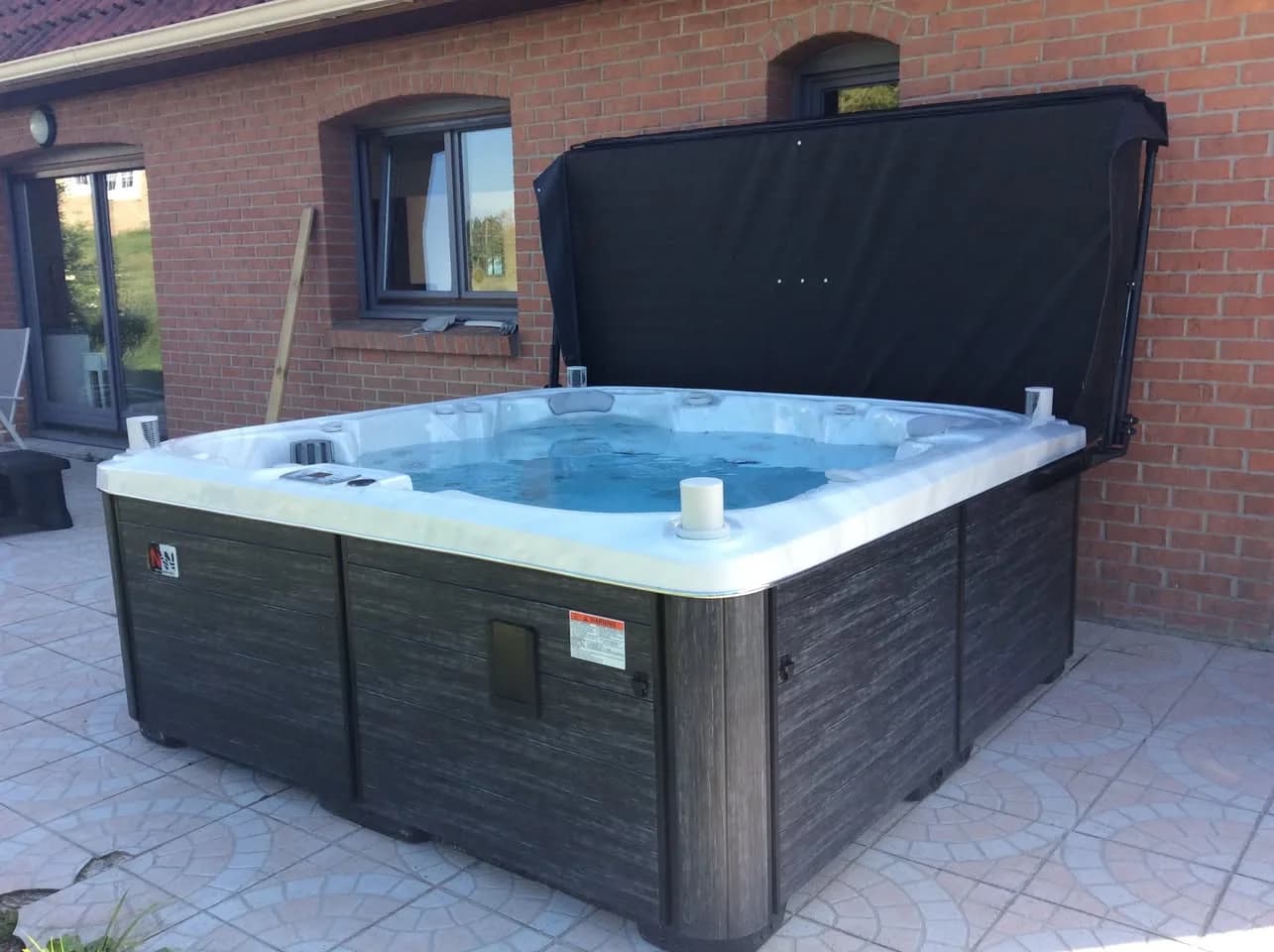 Installation d'un spa Søvik dans le Pas-de-Calais, sur une terrasse carrelée, contre une maison en brique