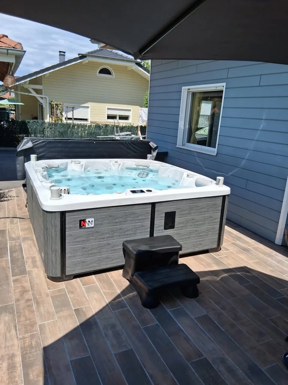 Installation d'un spa Søvik à Draillant, sur une terrasse carrelée contre la maison
