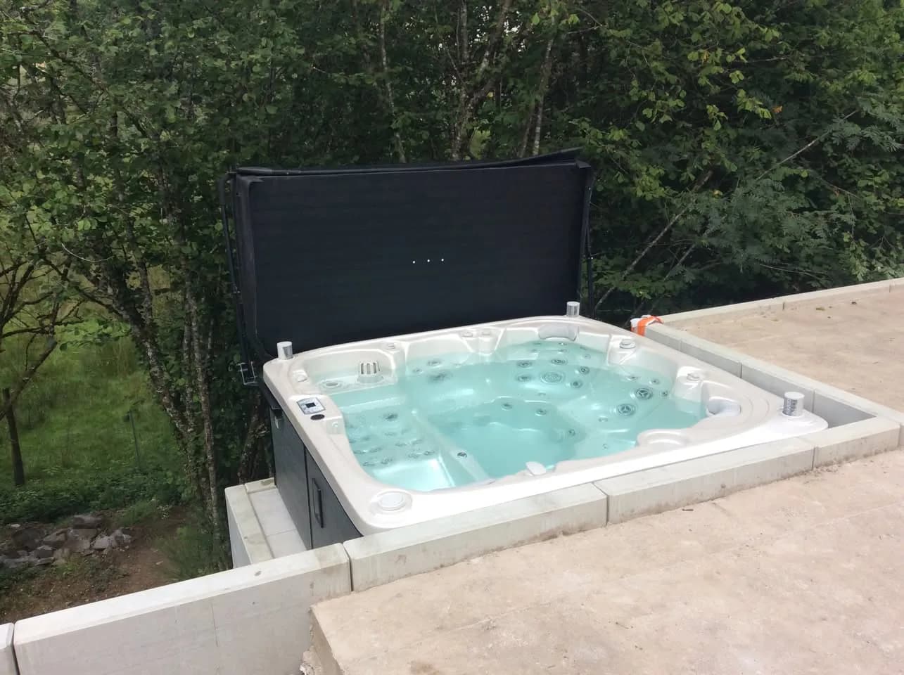 Installation d'un spa Søvik Full option à Le Thillot, encastré dans une terrasse au bord d'un étang