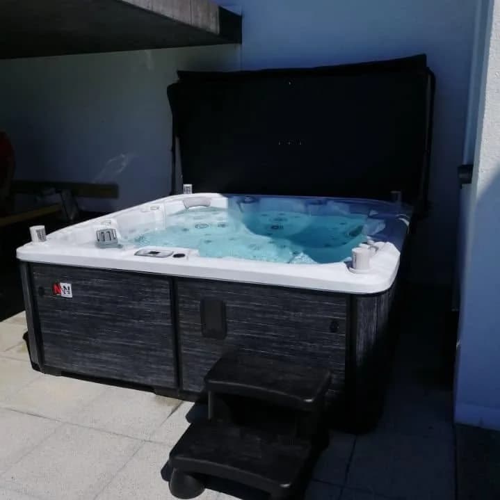 Installation d'un spa Søvik Full option à Porrentruy, sous un abri contre la maison