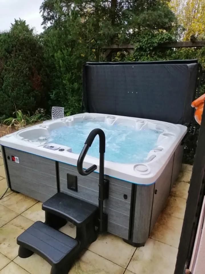 Installation d'un spa Søvik Full option à Schlierbach, sur une terrasse carrelée, barre d'appui