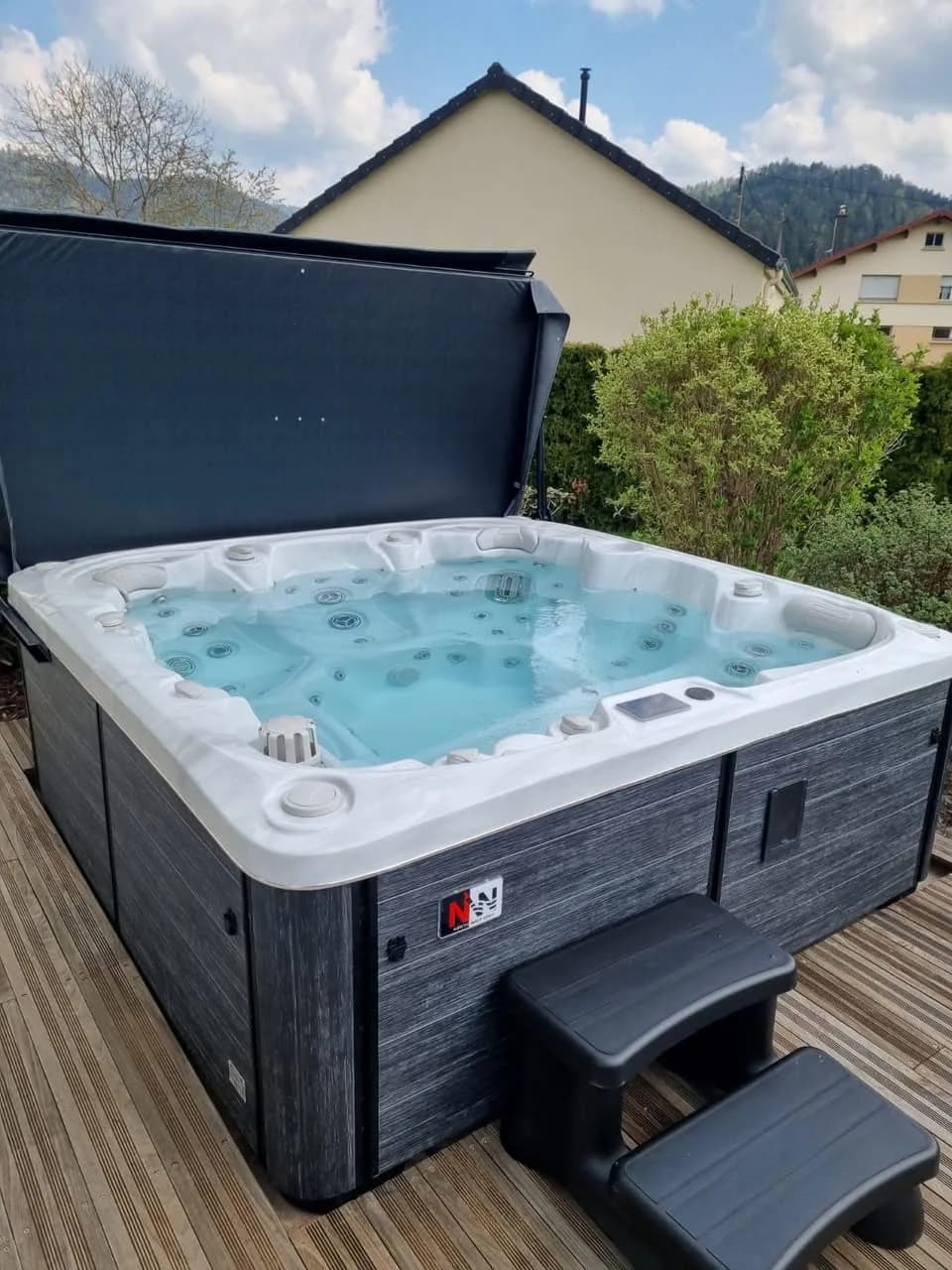 Installation d'un spa Søvik à Vagney, sur une terrasse en bois, lève-couverture et marchepied
