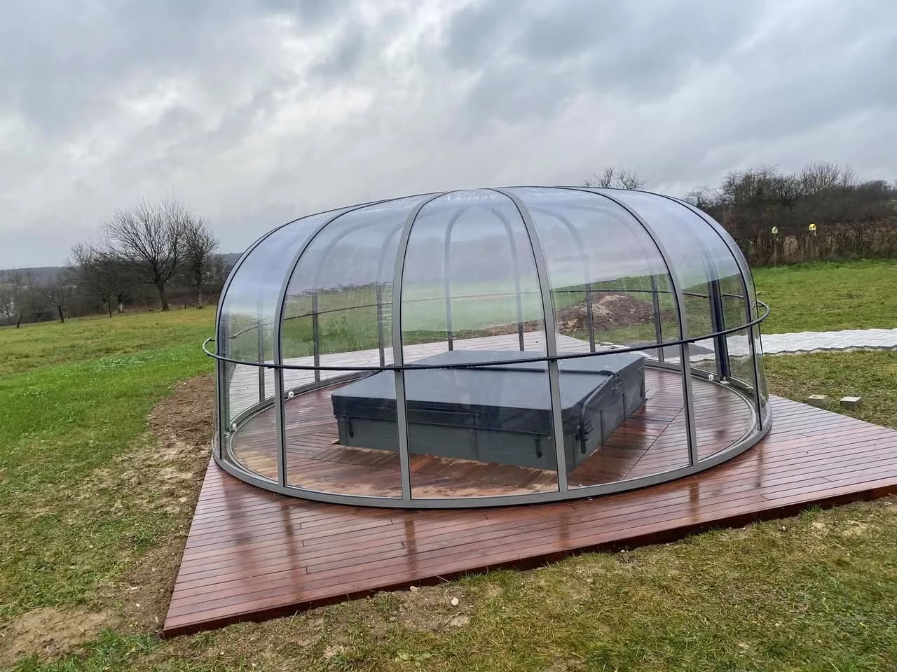 Installation d'un spa Sydney à Dasle, sous un dôme transparent, sur une terrasse en bois