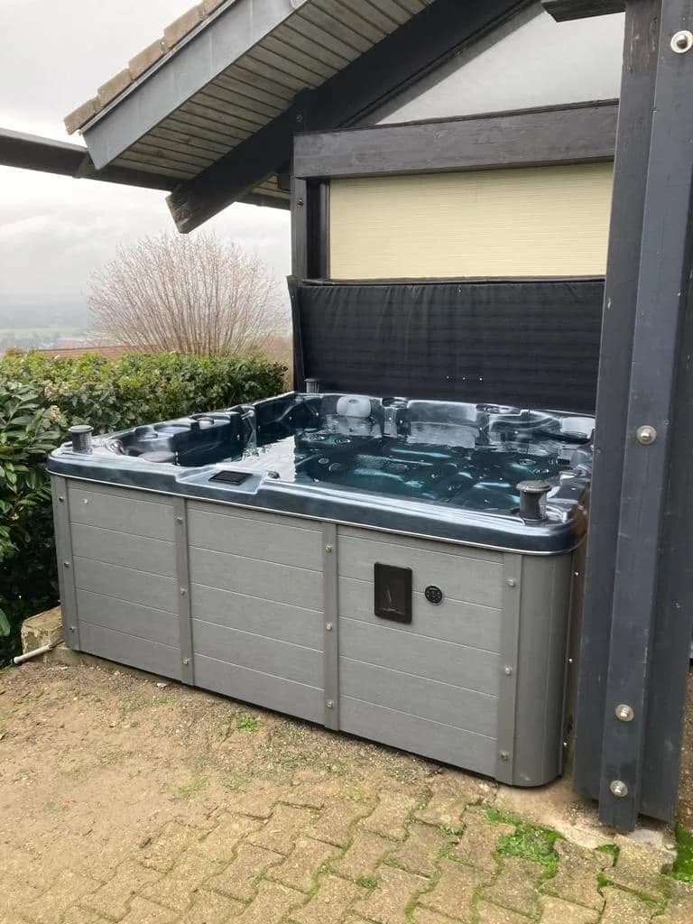 Installation d'un spa Sydney Full option à Ballaison, sous un auvent, sur des pavés