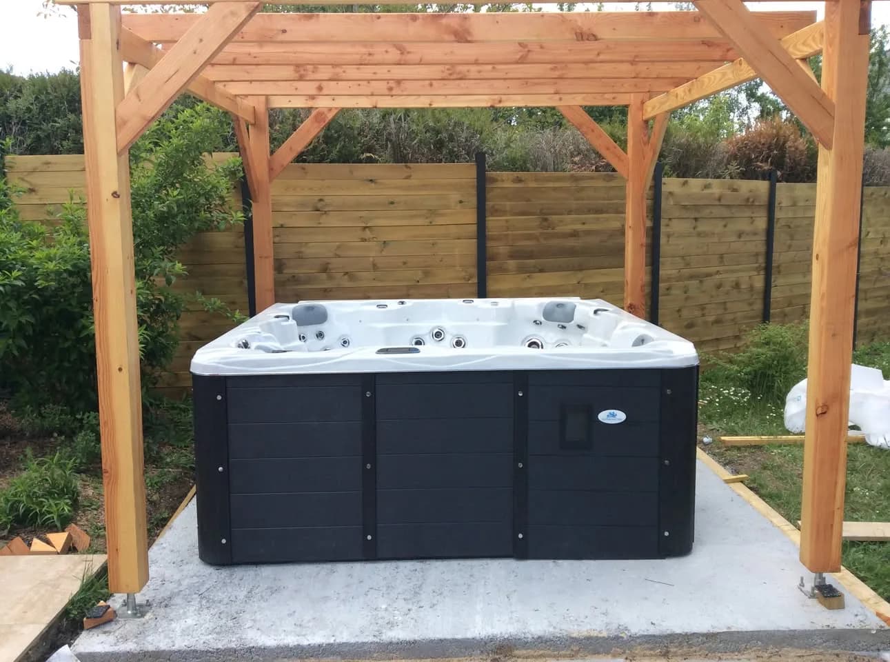 Installation d'un spa Sydney Full option à Olivet, sous une pergola en bois, sur une dalle béton