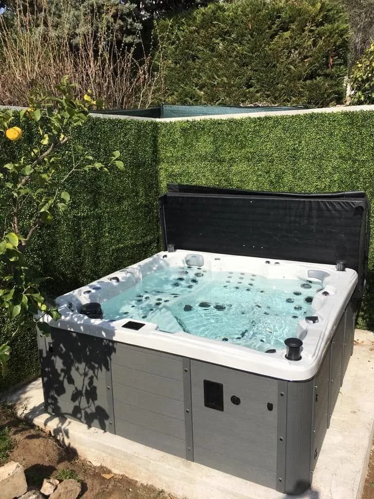 Installation d'un spa Sydney Full option à Saint-Jean-Cap-Ferrat, devant une haie, à côté d'un citronnier