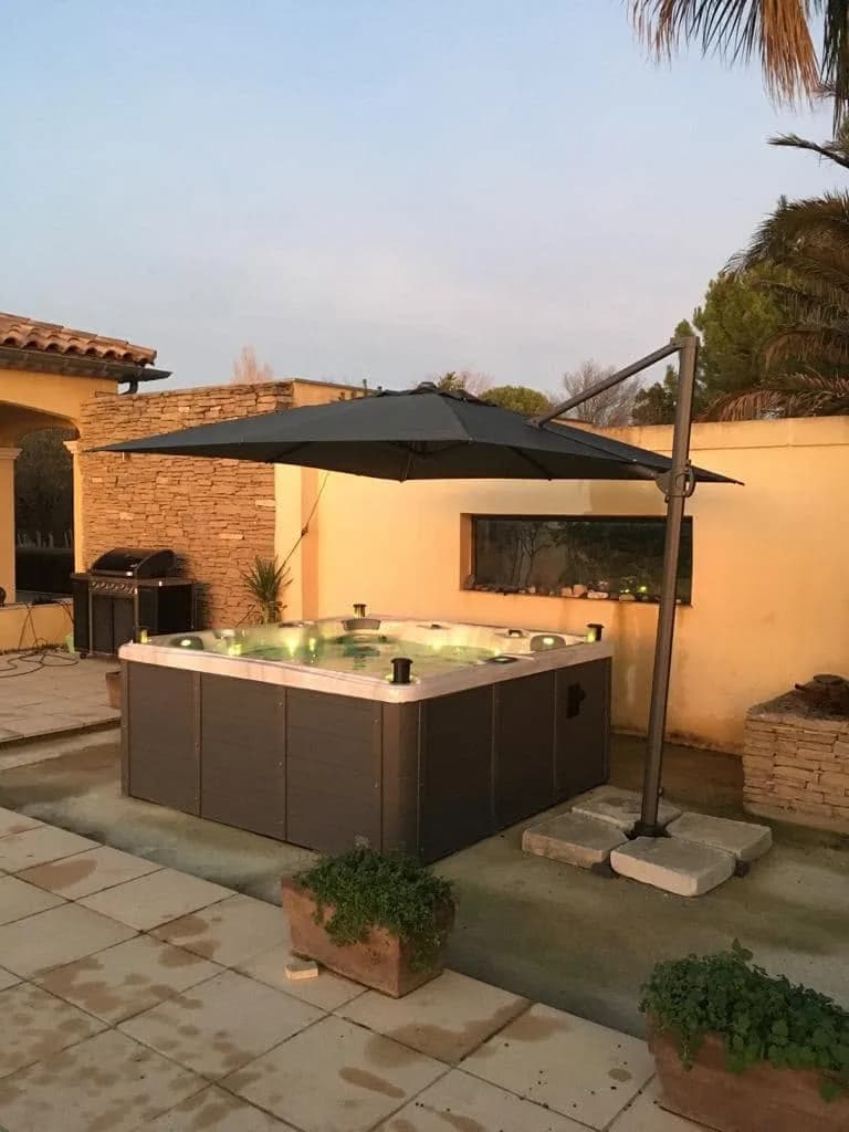 Installation d'un spa Sydney Full option à Teyran, sur une terrasse dallée sous un parasol