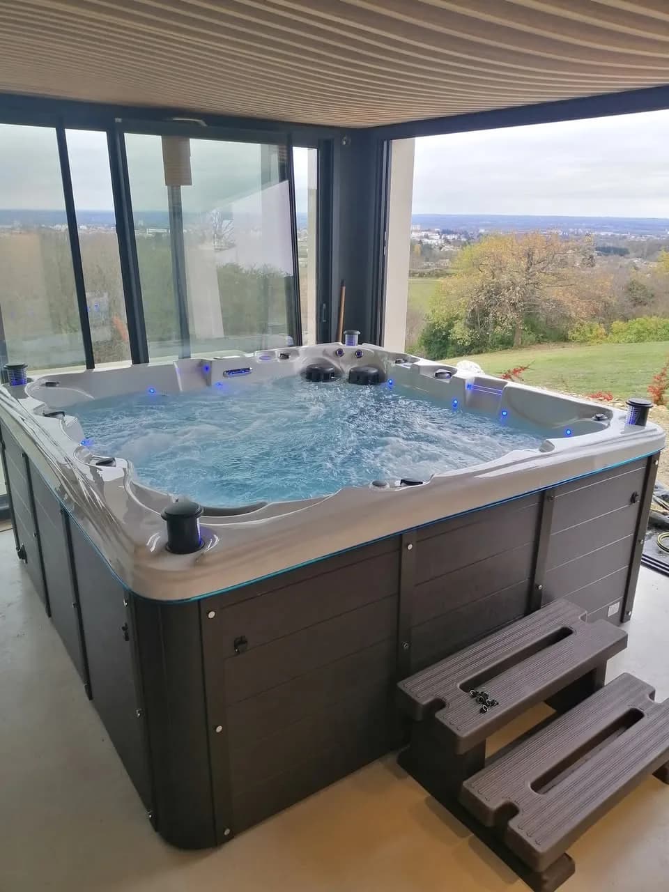 Installation d'un spa Sydney à Mâcon, dans une véranda, vue sur la campagne